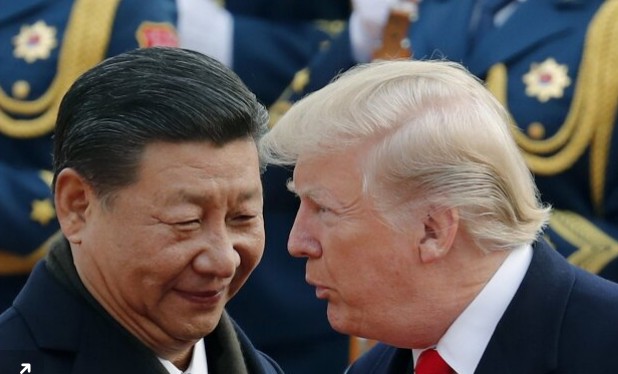 In this Nov. 9, 2017 photo, U.S. president, Donald Trump, right chats with Chinese president, Xi Jinping during a welcome ceremony at the great hall of the people in Beijing